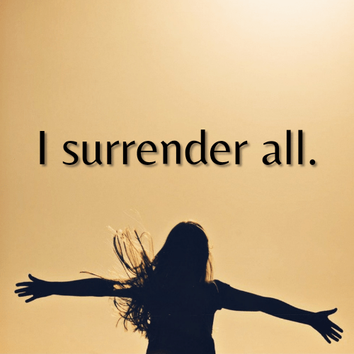 A woman throws her hands up in surrendering everything to Jesus.