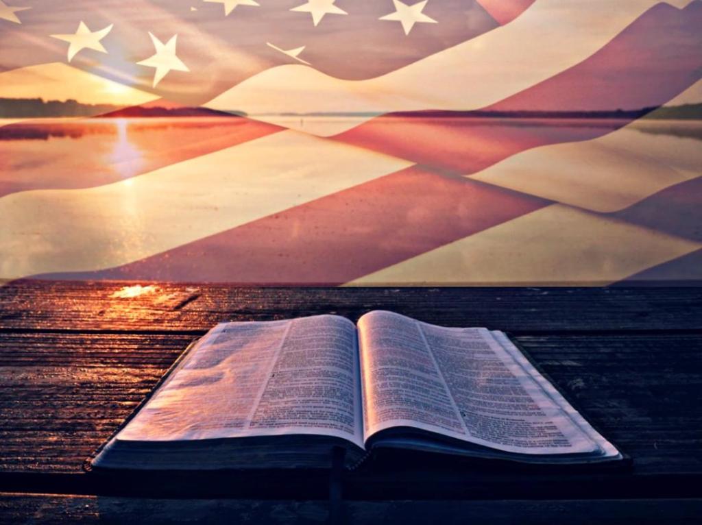 A Bible lies open under an American flag.